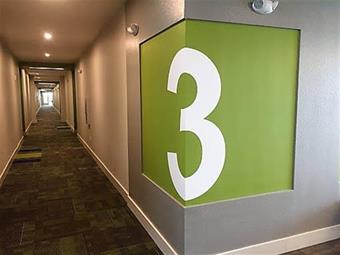 A collection of branded wayfinding signs and wall graphics