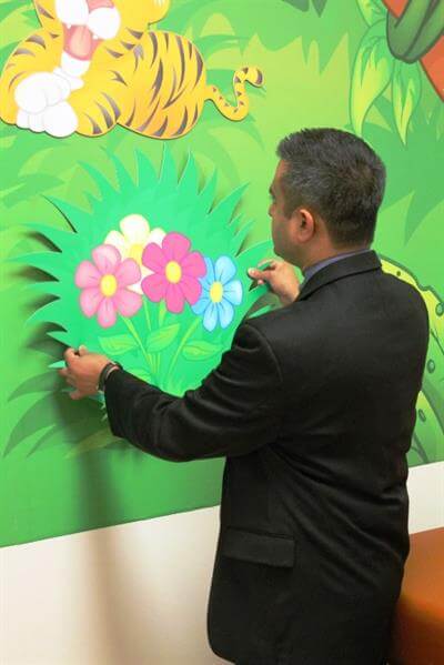 man installing flower design on the wall
