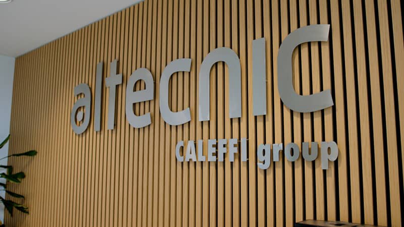 An image of the Altecnic Caleffi Group interior signage along a wood paneled wall.