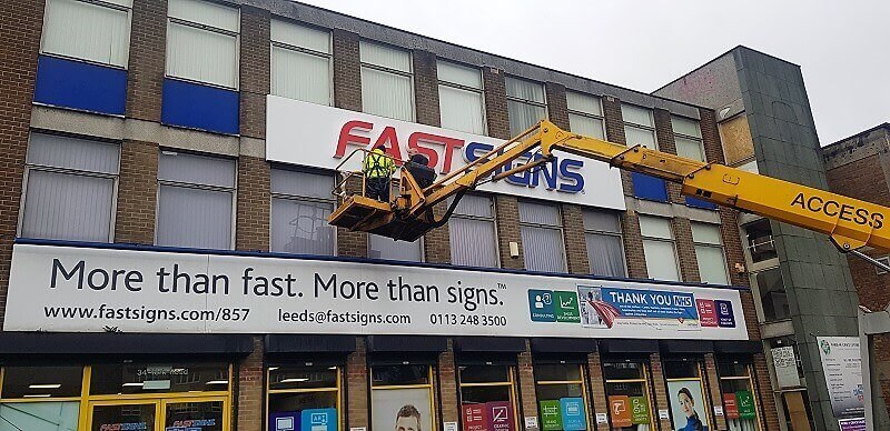 Men cleaning outdoor signage