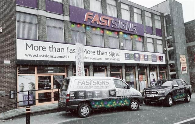 fastsigns shop front with vehicles