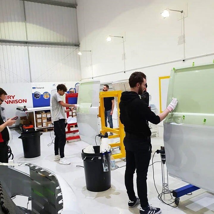 People painting parts of the van